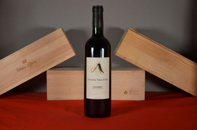 a bottle of wine sitting on a table next to two wooden boxes