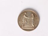 an image of a coin with a statue on it on a white surface
