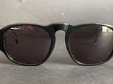 black sunglasses with brown lenses sitting on a gray surface