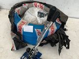 a blue bucket filled with garbage and a clamp on the floor