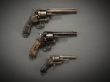 three old revolvers are sitting on a table with a black background