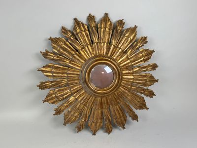 un soleil doré rayonnant, orné d'une pierre rose