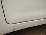 a dirty white car with a black stripe on the side