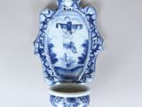 a blue and white vase with a picture of jesus on it