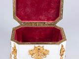 a white and gold box with a red velvet lining