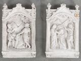 three white sculptures of a man and a woman on a wall