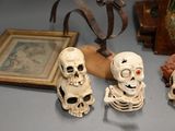 three skulls sitting on a table next to a framed picture