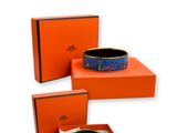 une boîte orange contenant un bracelet bleu et noir