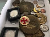 une boîte remplie de pièces et de médailles posée sur une table