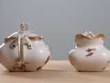 two white vases sitting on a wooden table