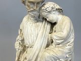 an old statue of a man holding a child in his arms