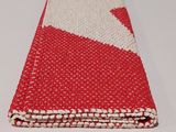 a close up of a red and white towel on a table