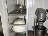 a metal cabinet with a mixer and a bowl in it