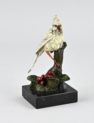 figurine of a cardinal perched on a branch with berries