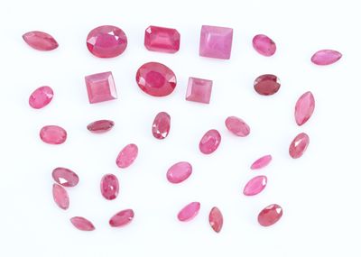 un gros plan sur un bouquet de pierres précieuses roses posées sur une surface blanche
