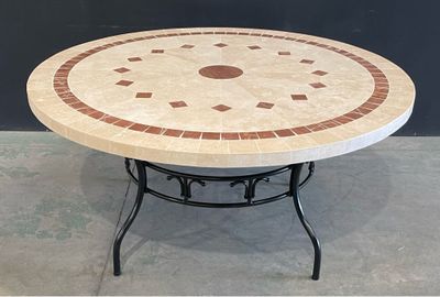 une table ronde avec un plateau en carrelage posée sur un piètement