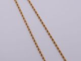 a gold chain necklace with a long link on a white background