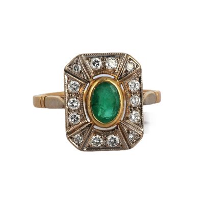 gros plan d'une bague en émeraude et diamant sur fond blanc