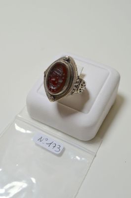 une bague en argent surmontée d'une pierre rouge