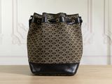 a brown and black bucket bag sitting on top of a wooden table