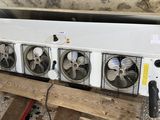 trois ventilateurs posés sur une palette