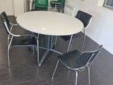 a white table with four chairs around it in a room