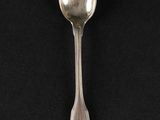 silver spoon on a black surface with a black background