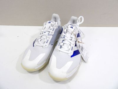 une paire de baskets blanches et bleues posées sur une table blanche