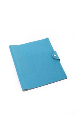 un cahier bleu avec un bouton sur la couverture
