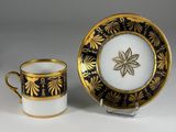 a black and gold cup and saucer