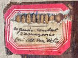 a label on a piece of wood with writing on it