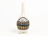 un vase blanc orné d'un motif noir et orange