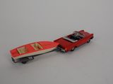 a red toy car with a boat on the back of it