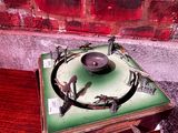 un vieux tourne-disque posé sur une table en bois, près d'un mur de briques