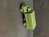 a green toy truck that is attached to a wall