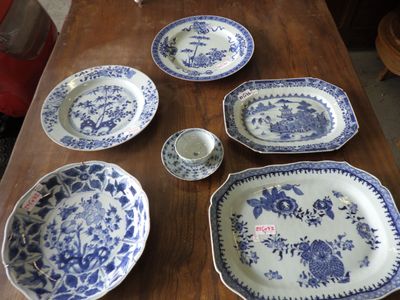 several blue and white plates and bowls on a wooden table