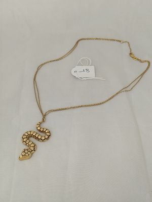 a close up of a necklace on a white cloth with a tag