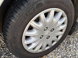 the tire of a white car with a flat tire on a gravel road