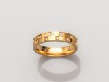 gros plan d'une bague en or avec des diamants sur une surface blanche