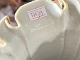 a close up of a white vase with a tag on it
