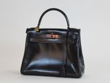 un sac à main en cuir noir posé sur une surface blanche