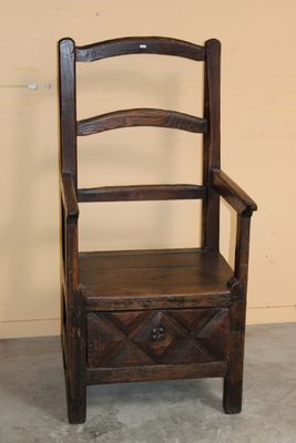 a wooden chair with a drawer underneath it in a room