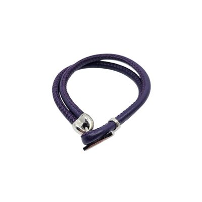 a close up of a purple leather bracelet on a white background