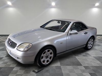 une photo d'une Mercedes SLK argentée garée dans un garage