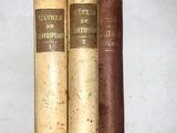 trois vieux livres posés côte à côte sur une table