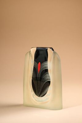un vase noir et blanc contenant un cœur rouge