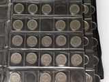a lot of coins in a black wallet on a white surface