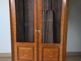 a wooden cabinet with a glass door on top of it