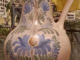 a vase that is sitting on a table in front of a picture