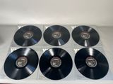 six black vinyl records on a table with a white background
